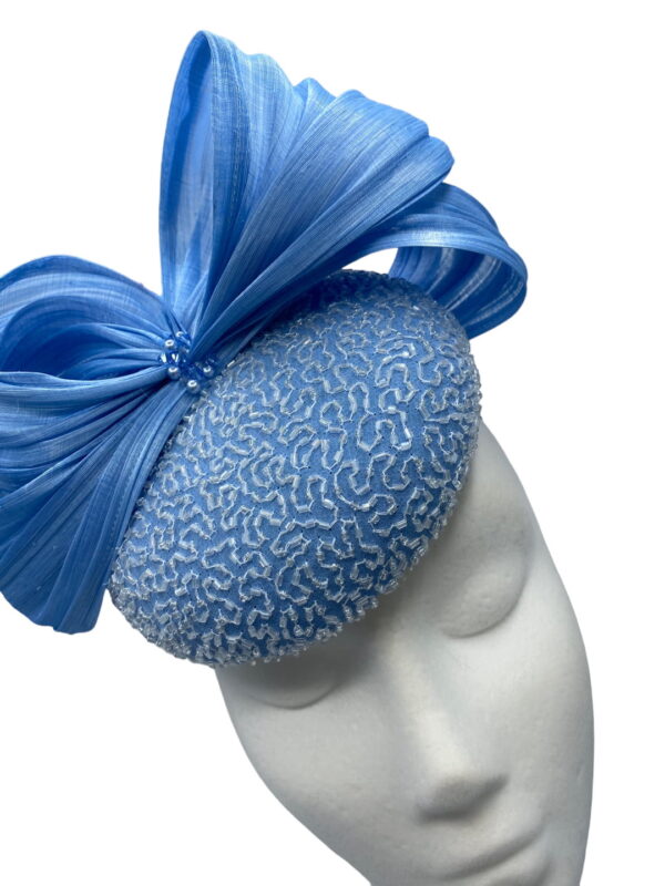 A beautiful blue beaded silk chiffon cocktail/percher hat, trimmed with luxurious silk abaca swirls and a splash of crystals and pearls.